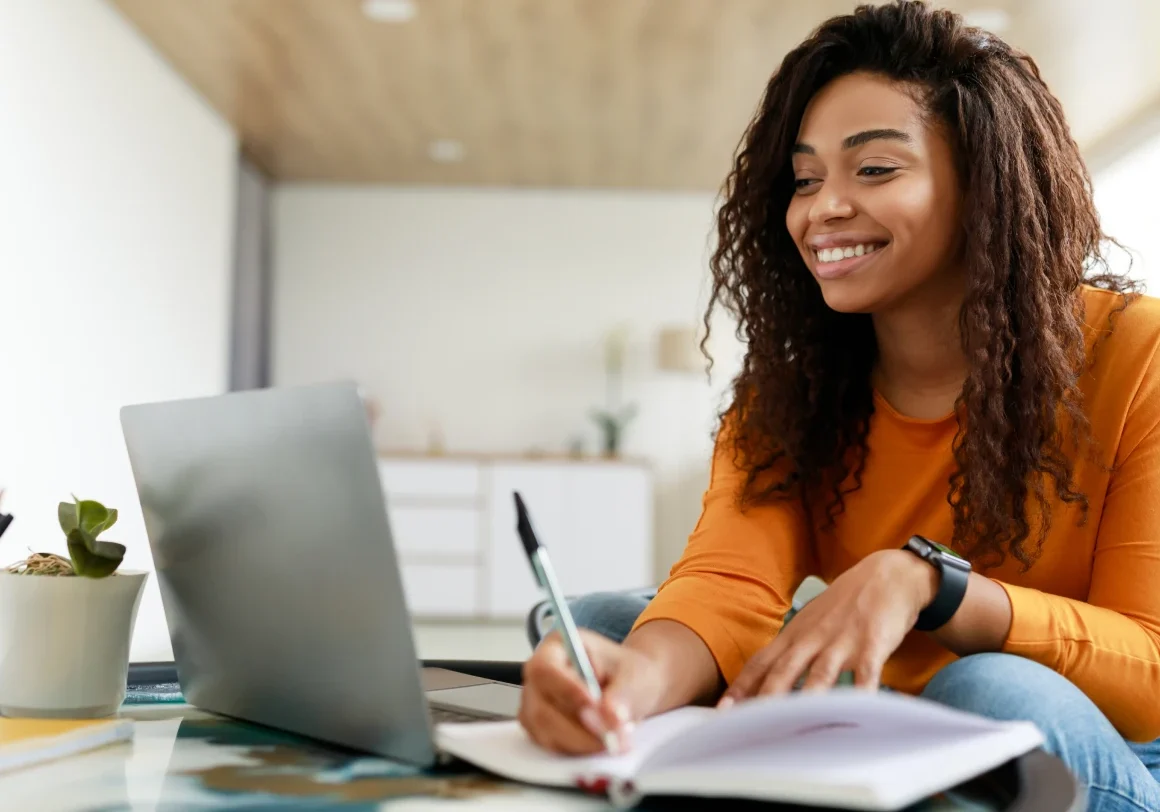 Woman taking notes during online meeting
